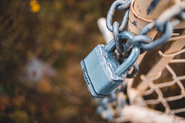 Okta Permiso identity https://www.pexels.com/photo/chain-link-fence-closed-with-lock-in-countryside-5688464/